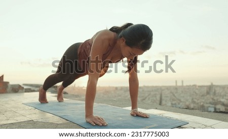 Girl practices handstand yoga asana at lookout point at dawn