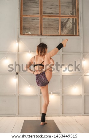 A girl practices yoga in a bright textured studio close-up. Meditation, woman, yoga, asanas, relaxation.
