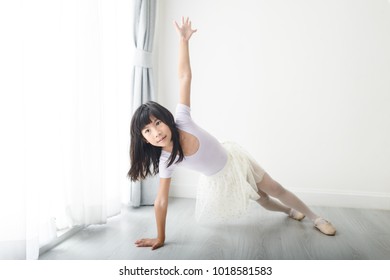 Girl Practicing Ballet Dance Near Window At Home.