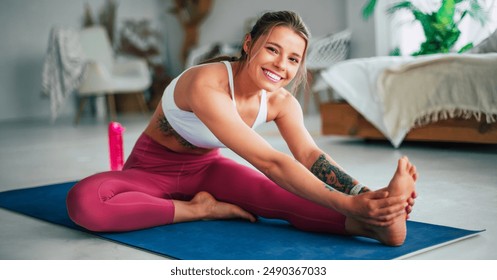 Girl practicing pilates, stretching exercises and doing yoga. Active young sporty slim woman is working out at home, sitting on exercise mat. Health, fitness, loss weight and good wellness - Powered by Shutterstock