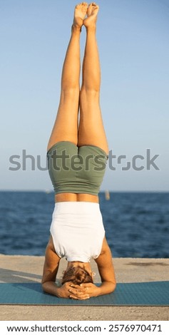 Similar – Image, Stock Photo Flexible woman performing headstand pose in yoga studio