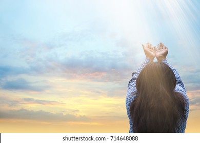 Girl praying and worship to GOD.woman praying to GOD in the morning.teenager woman hand praying,Raised Hands in prayer on the sky in the morning concept for faith, spirituality and religion.