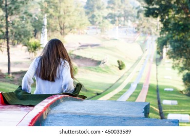 Girl Prepares To Slide On Red Toboggan