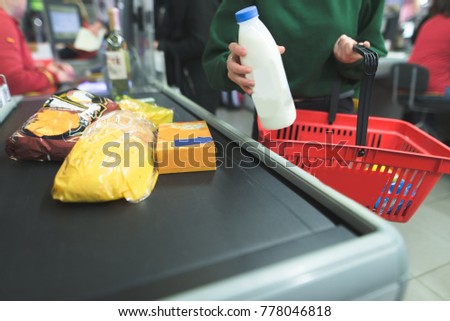 A girl presents products to the supermarket cash desk.