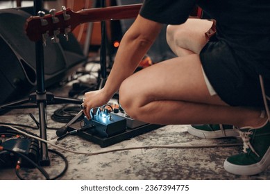 girl pressing button on a guitar pedal in a recording room. selective focus - Powered by Shutterstock