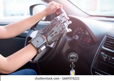 A girl with a prosthetic arm drives a car. The concept of a full life for people with disabilities. Side view, small depth of field.