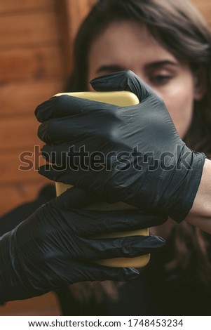 the girl protected herself from the virus by putting on latex gloves in her hands to hold the phone.