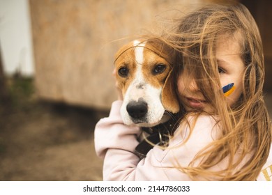 The girl is protecting her dog. Girl and her dog. A refugee from Ukraine with a dog. Animal rescue from Ukraine. Evacuation of dogs. The girl hugs and calms her dog.