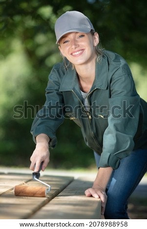 a girl in protective glasses working on a wooden board