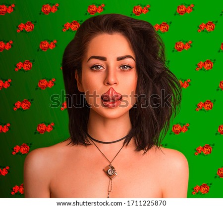 Girl pulls out her tongue to the tip o her nose, green background