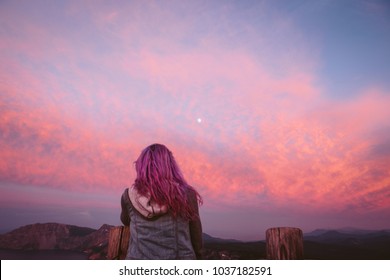 Girl with purple hair looking at pink sunset and moon - Powered by Shutterstock