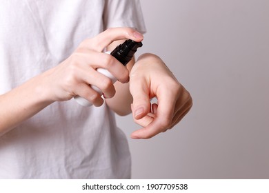 Girl puts cosmetic oil on her hands - Shutterstock ID 1907709538