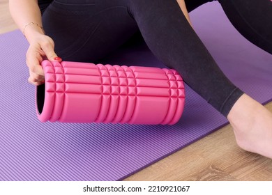 The Girl Puts A Foam Roller Under Her Leg For A Fitness Massage. Legs Close Up. Pregnant Yoga Practice Concept