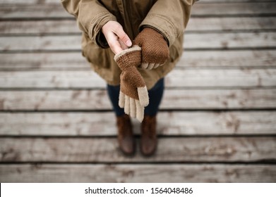 girl puts on her hands warm winter wool gloves