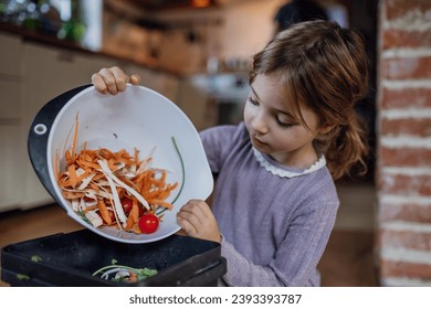 Girl putting kitchen waste, peel and leftover vegetables scraps into kitchen compostable waste. Concept of composting kitchen biodegradable waste. - Powered by Shutterstock