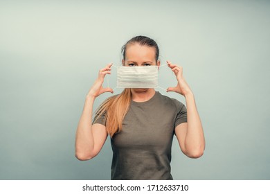 A girl is putting on a protective mask. Respiratory protection from coronavirus. Personal protective equipment for a pandemic of a viral infection. Covid-19 - Shutterstock ID 1712633710