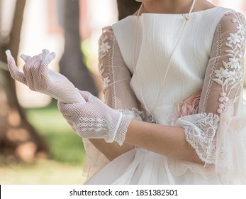 Girl Putting On White Lace Gloves