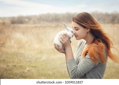the girl with the rabbit.happy little girl holding cute fluffy Bunny.Friendship with Easter Bunny. Spring photo with beautiful young girl with her Bunny. Girl is holding a cute little rabbit