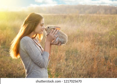 the girl with the rabbit.happy little girl holding cute fluffy Bunny.Friendship with Easter Bunny. Spring photo with beautiful young girl with her Bunny. Girl is holding a cute little rabbit
