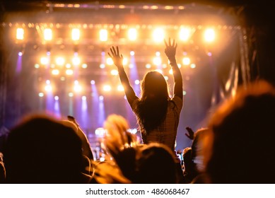 Girl Raising Her Hands And Enjoying A Great Concert.