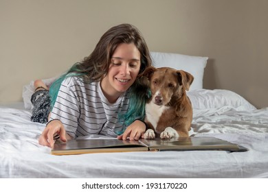 girl reading a book for her dog in the bedroom