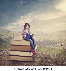 Girl Reading A Book On A Stack Of Books