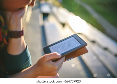 Girl reading e-book in sunny evening, selective focus