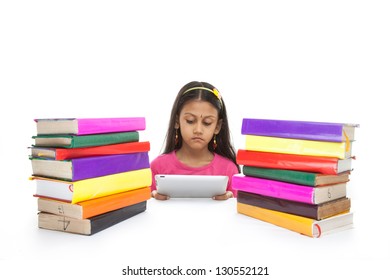 Girl reading e-book surrounded by several books, isolated on white background