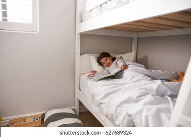 Girl Reading Story In Bunk Bed At Bedtime