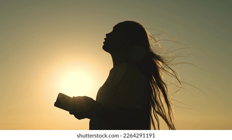 girl reads bible book sunset. bible hand. sun book. pray sunset reading bible. man girl ask forgiveness from sun. religious man reads book rays sunlight. travel millennium with book. prayer read. - Powered by Shutterstock