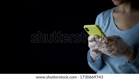 A girl reads news online. Uses the phone in disposable latex transparent gloves. New reality.