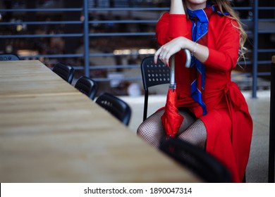 Girl In A Red Coat Indoors, Cafe, Shops Is Standing With A Red Umbrella, Waiting For A Meeting