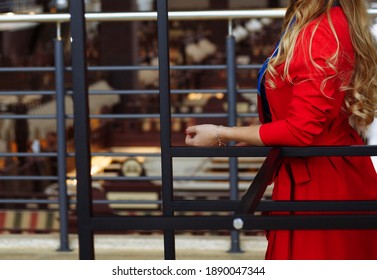 Girl In A Red Coat Indoors, Cafe, Shops Is Standing With A Red Umbrella, Waiting For A Meeting