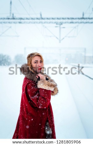 Girl in a red coat posing outdoors in winter