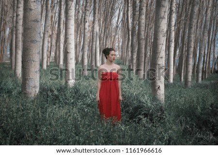 Mädchen in rotem Kleid im Wald