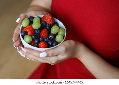 Girl in red dress holding plate of berries. White plate with strawberry , green grape and blueberry. Healthy lifestyle. Fruit vitamin. Fruit salad - Shutterstock ID 1645744465