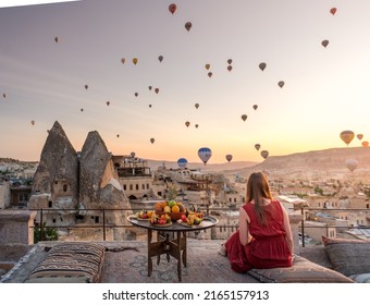 Girl In Red Dress Looking At Hot Air Balloons Over Cappadocia