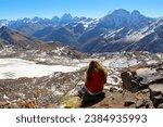 The girl with the red hair flying on the wind sitting and enjoying the mountain view, Mount Elbrus region, Russia. Sunny day