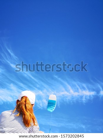Girl with red hair study kite on summer vacation.