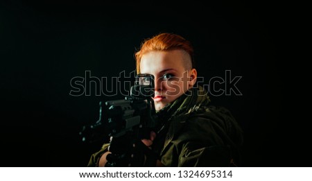 Girl with red hair, takes aim at the sight in military uniform. Horizontal background
