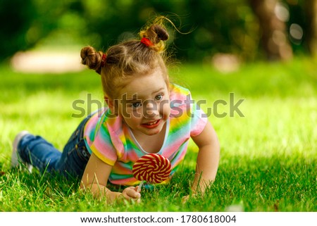 Similar – Littel girl sitting on grass looking curious