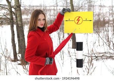 girl in red points to a high voltage power grid hazard sign  - Shutterstock ID 1924196498