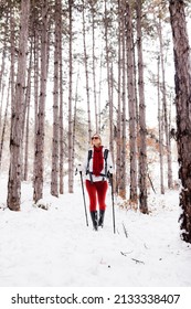 Girl In Red And White Outfit Hiking In A Forest With Snow On A Winter Day