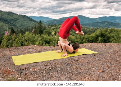 Girl In Red Yoga Pants Doing Sirsa Padasana (scorpion) Asana In The Mountains