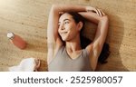 Girl, relax and fitness with thinking on floor with top view for yoga break, tired of pilates or exercise. Woman, yogi or happy person on mat in home with water bottle, peaceful or fatigue of workout