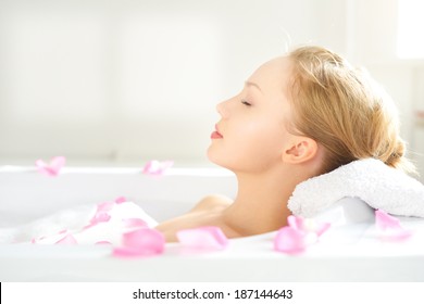 girl relaxing in bathtub on light background - Powered by Shutterstock