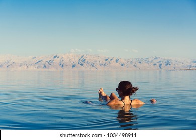 Girl is relaxing and swimming in the water of the Dead Sea in Israel