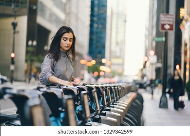 Girl Renting A City Bike From A Bike Stand In Chicago