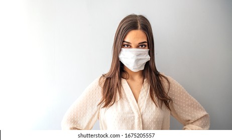 Girl In Respiratory Mask. Masked Woman Looks At Camera. Cold, Flu, Virus, Tonsillitis, Respiratory Disease, Quarantine, Epidemic Concept. Beautiful Caucasian Young Woman With Disposable Face Mask