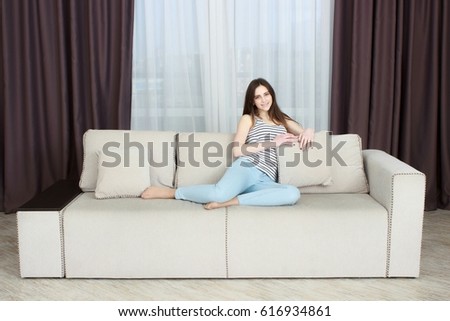 The girl is resting on the couch In the interior of the apartments